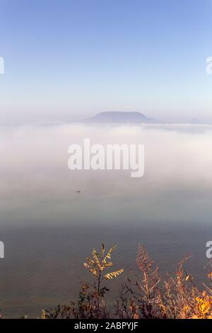 Blick auf den nebligen Plattensee Badacsony Fonyod Promenade mit den im Hintergrund an einem Herbsttag. Stockfoto