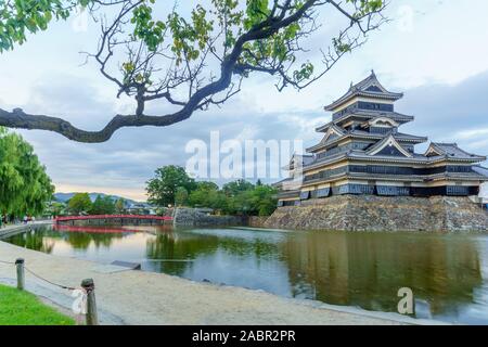 Matsumoto, Japan - 30. September 2019: Sonnenuntergang Blick auf das Schloß Matsumoto (oder Krähe Schloss) und Brücke, mit Besuchern, in Matsumoto, Japan Stockfoto