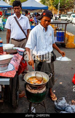 Ein Mann Kochen an einer Garküche in der Innenstadt von Rangun, Yangon, Myanmar. Stockfoto