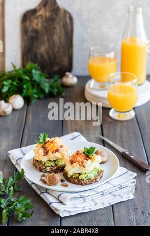 Sandwich mit Avocado und Orsini Ei auf Getreide Brot mit geröstetem Speck zum Frühstück. Leichte und gesunde Frühstück von einfachen Produkten. Comforta Stockfoto