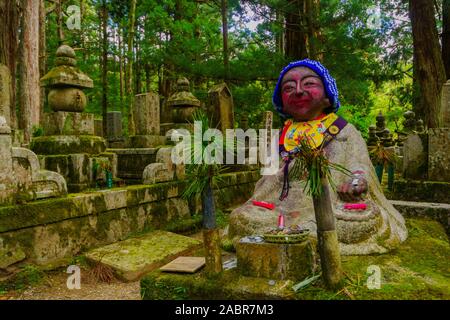 Koyasan, Japan - Oktober 7, 2019: Blick von Gräbern und Jizo (Japanische Boddhisattva Statuen, die in einem roten Tuch gekleidet) im Friedhof Okunoin, Mount Koya (K Stockfoto