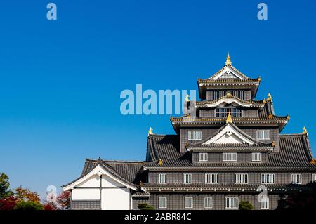 Okayama Castle Black Samurai Festung mit blauen hellen Himmel im Herbst. Japan Edo historische Schloss Stockfoto