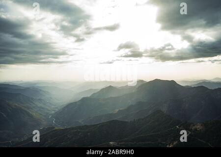 Fabelhafte Aussicht von Moro Rock im Sequoia National Park mit einem nebligen Berge im Hintergrund und schönen Sonnenstrahlen Hervorhebung der Horizont, Californi Stockfoto