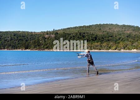 Fischer casting seinen Stab auf den Strand Stockfoto