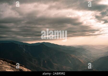 Fabelhafte Aussicht von Moro Rock im Sequoia National Park mit einem nebligen Berge im Hintergrund und schönen Sonnenstrahlen Hervorhebung der Horizont, Californi Stockfoto