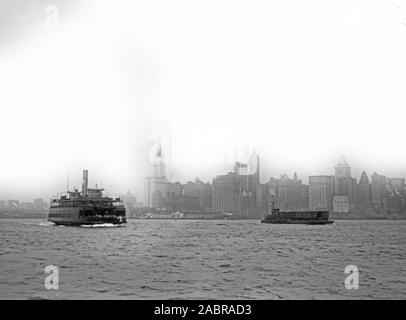 Foto zeigt Lower Manhattan, New York City, mit der Fähre in den Vordergrund. Identifizierte Gebäude gehören (von links): Woolworth Building (mit Turm kurz vor dem Abschluss), Hudson Terminal, West Street, City Tower, Sänger Gebäude investieren, US-Immo und Trinity Gebäude, United States Express Company, Bankers Trust Tower, und 47 West Street Gebäude. Stockfoto