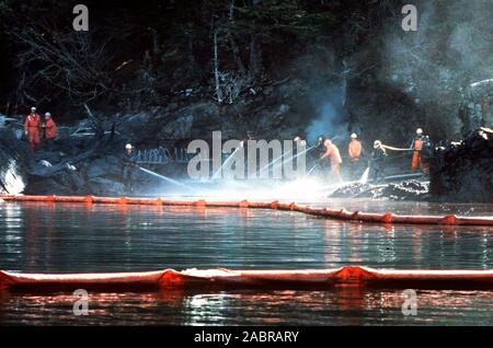 Prince William Sound, Alaska (Mar. 28) - Arbeiter steam blast Rocks getränkt in Rohöl aus der undichte Tanker Exxon Valdez. Der Exxon Valdez strandete auf Bligh Riff im Prince William Sound, Alaska, 23. März 1989 auslaufen 11 Millionen Liter Rohöl, die in die größte Ölpest in der Geschichte der USA geführt. Stockfoto