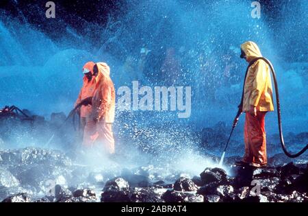 Prince William Sound, Alaska (Mar. 28) - Arbeiter steam blast Rocks getränkt in Rohöl aus der undichte Tanker Exxon Valdez. Der Exxon Valdez strandete auf Bligh Riff im Prince William Sound, Alaska, 23. März 1989 auslaufen 11 Millionen Liter Rohöl, die in die größte Ölpest in der Geschichte der USA geführt. Stockfoto