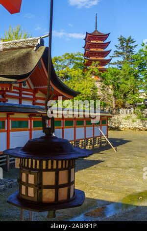 Miyajima, Japan - Oktober 13, 2019: Blick auf den Itsukushima Schrein, bei Ebbe, und das 5-stöckige Pagode (Gojunoto), mit Besuchern, in Miyajima (I Stockfoto