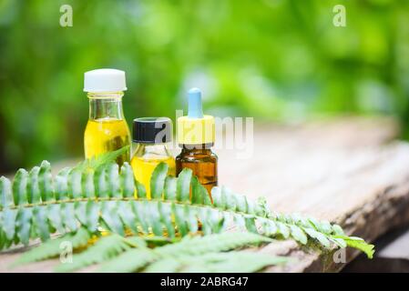 Aromatherapie pflanzliche Öl Flaschen Aroma mit farnblätter pflanzliche Formulierungen einschließlich Wildblumen und Kräutern auf Holz/Ätherische Öle natürliche auf Holz Stockfoto