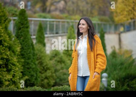 Draußen. Angenehme hübsche Frau, die sich in den Garten, während Sie zu Fuß genießen. Stockfoto