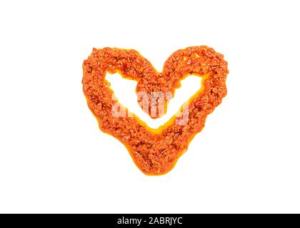 Sun-Dried Tomato Pesto in Form eines Herzens isoliert auf weißem Stockfoto