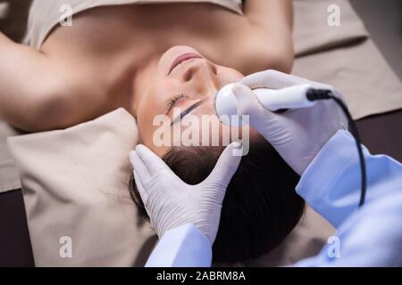 Junge Frau mit Ultraschall Gesichtsbehandlungen Beauty Behandlung Hautpflege Stockfoto