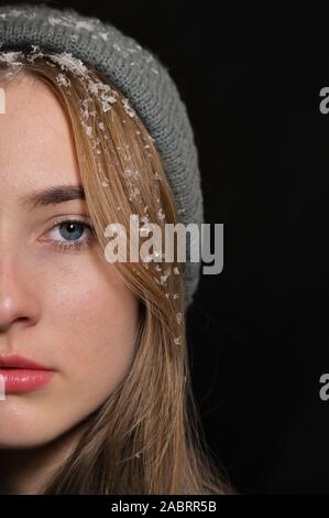 Nahaufnahme Portrait von blue-eyed Mädchen mit Schnee im Haar Stockfoto