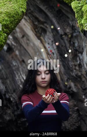 Junges Mädchen mit den Ball in den Wald. Ornamente Schneeflocken fallen. Stockfoto