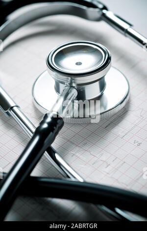 Nahaufnahme eines Elektrokardiogramms in Papierform und ein Stethoskop. Stockfoto