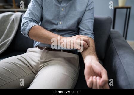 Nahaufnahme einer afrikanischen Mann seine Hand Kratzen Stockfoto