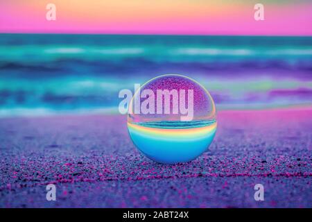 Eine schöne selektiven Fokus Schuß einer Kristallkugel, die den atemberaubenden Sonnenuntergang mit einzigartigen Farben Stockfoto