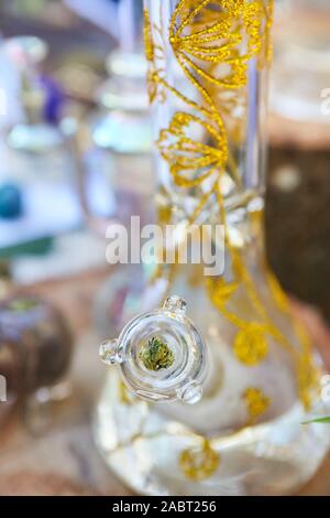Eine vertikale closeup Schuß eines Cannabis Bong mit goldenen Mustern auf unscharfen Hintergrund Stockfoto