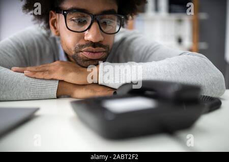 Junge Unternehmer, die auf einen Anruf warten auf Festnetz Stockfoto