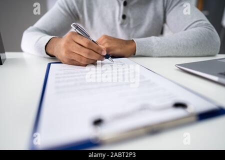 Nahaufnahme der Geschäftsmann hält Stift zur Anmeldung auf dem Vertrag Papier Stockfoto