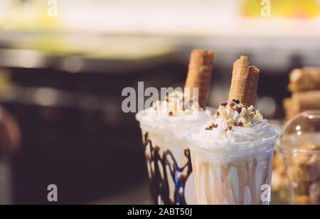 Schlagsahne Milchshake garniert mit einer Waffel roll und Sirup. Stockfoto