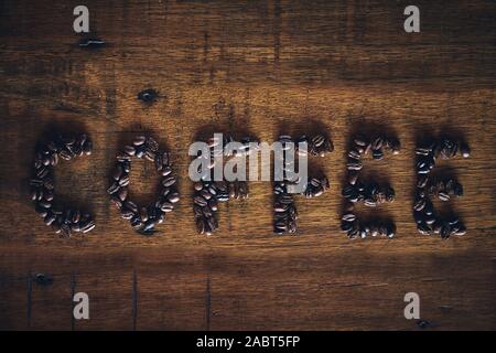 Kaffee text/Wort mit gerösteten Arabica Kaffeebohnen auf rustikalen hölzernen Hintergrund Stockfoto