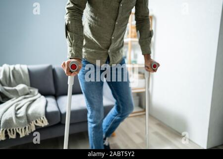 Behinderte Menschen mit Krücken zu Fuß auf dem Boden Stockfoto