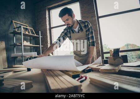 Porträt Seiner er schöne attraktive ernste konzentriert arbeitende qualifizierte erfahrene Kerl Handwerker lesen planen Neues Haus bei modernen Stockfoto