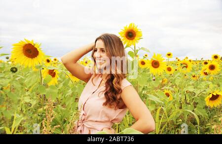 Schöne Frau in einem Sonnenblumenfeld Stockfoto