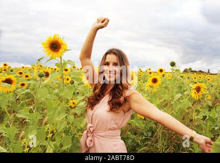 Schöne Frau in einem Sonnenblumenfeld Stockfoto