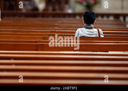 Abtei Fleury ist einer der am meisten gefeierten Benediktinerklöster. Betende Frau in der Kirche. Saint Benoit sur Loire. Frankreich. Stockfoto