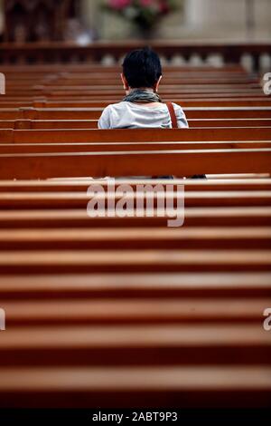 Abtei Fleury ist einer der am meisten gefeierten Benediktinerklöster. Betende Frau in der Kirche. Saint Benoit sur Loire. Frankreich. Stockfoto