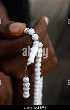 African Muslim Mann, der betet. Das islamische Gebet Perlen (tasbih). Close-up auf Händen. Togo. Stockfoto