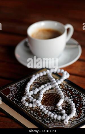 Das islamische Gebet Perlen, Koran und Tasse Kaffee. Stockfoto
