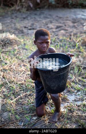 Junge Bewässerung ein Feld in Karsome, Togo. Stockfoto
