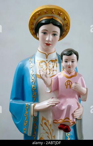 Statue Unserer Lieben Frau von La Vang in Ao Dai Kleid. Phu Cam Kathedrale. Farbton. Vietnam. Stockfoto