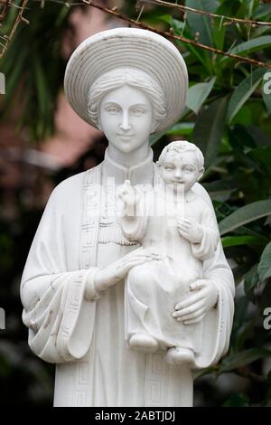 Statue Unserer Lieben Frau von La Vang in Ao Dai Kleid. Phu Cam Kathedrale. Farbton. Vietnam. Stockfoto