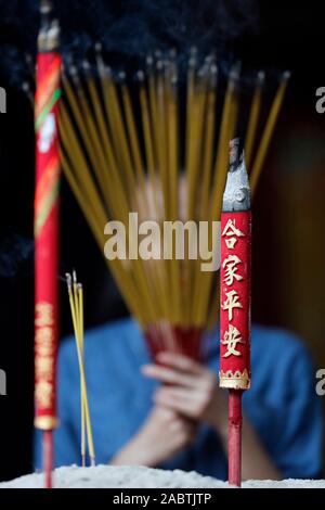 Ha Chuong Hoi Quan Pagode. Junge chinesische betende Frau mit großen Räucherstäbchen in der Hand. Ho Chi Minh City. Vietnam. Stockfoto