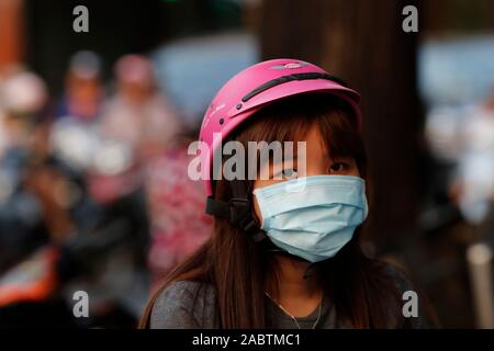 Junge Frau auf einem Motorrad mit Schutz Maske im Gesicht. Ho Chi Minh City. Vietnam. Stockfoto