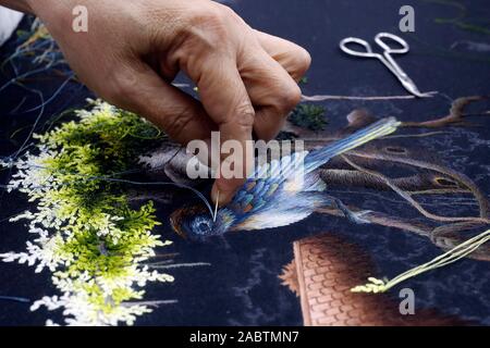 Junge weibliche Arbeitnehmer tun Stickerei. Vogel. Close-up auf der Hand. Farbton. Vietnam. Stockfoto