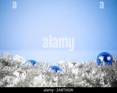 Weihnachten Kopie Raum mit hellen blauen und silbernen Kugeln in Silber dekorative Kette Girlande auf hellblauem Hintergrund mit bokeh Effect Stockfoto