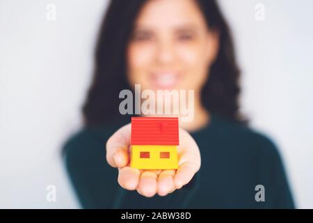 Woman holding Modell Haus in Händen auf weißem Hintergrund Stockfoto