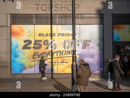 Die Oxford Street, London, UK. 29. November 2019. Sun Winter bringt Käufer auf der Suche nach Schwarzer Freitag Rabatte in Londons Premier Shopping Street. Verkauf Poster decken die Fassade der Top Shop Flagship Store in Oxford Circus. Credit: Malcolm Park/Alamy Leben Nachrichten. Stockfoto