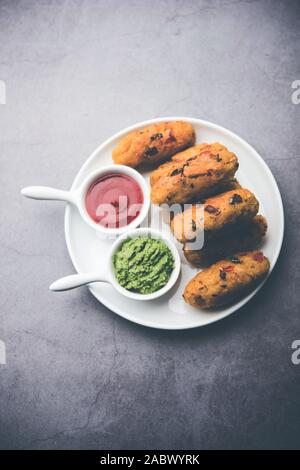 Gemüse Poha Schnitzel oder abgeflachte Reispasteten serviert mit Tomatenketchup und grünem Chutney Stockfoto