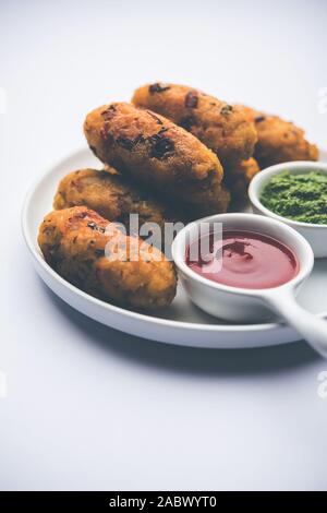 Gemüse Poha Schnitzel oder abgeflachte Reispasteten serviert mit Tomatenketchup und grünem Chutney Stockfoto