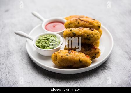 Gemüse Poha Schnitzel oder abgeflachte Reispasteten serviert mit Tomatenketchup und grünem Chutney Stockfoto