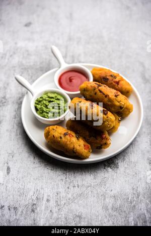 Gemüse Poha Schnitzel oder abgeflachte Reispasteten serviert mit Tomatenketchup und grünem Chutney Stockfoto