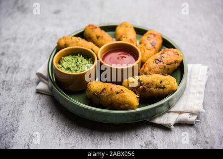 Gemüse Poha Schnitzel oder abgeflachte Reispasteten serviert mit Tomatenketchup und grünem Chutney Stockfoto