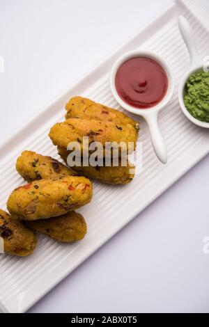Gemüse Poha Schnitzel oder abgeflachte Reispasteten serviert mit Tomatenketchup und grünem Chutney Stockfoto